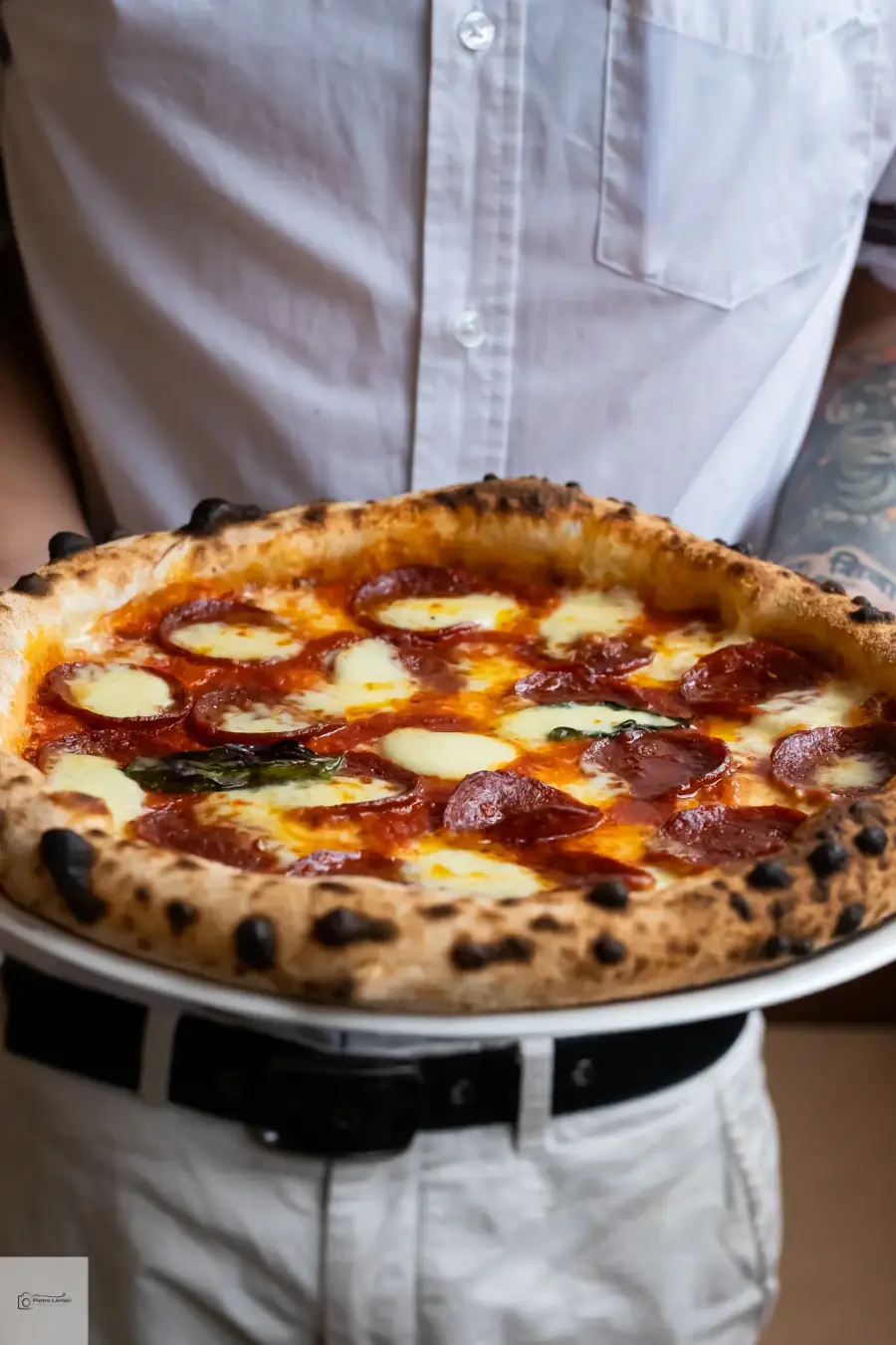 Bel Fiore Pizza Catering chef holding a handcrafted wood-fired salami Diavola pizza — Neapolitan mastery at Sydney catering events